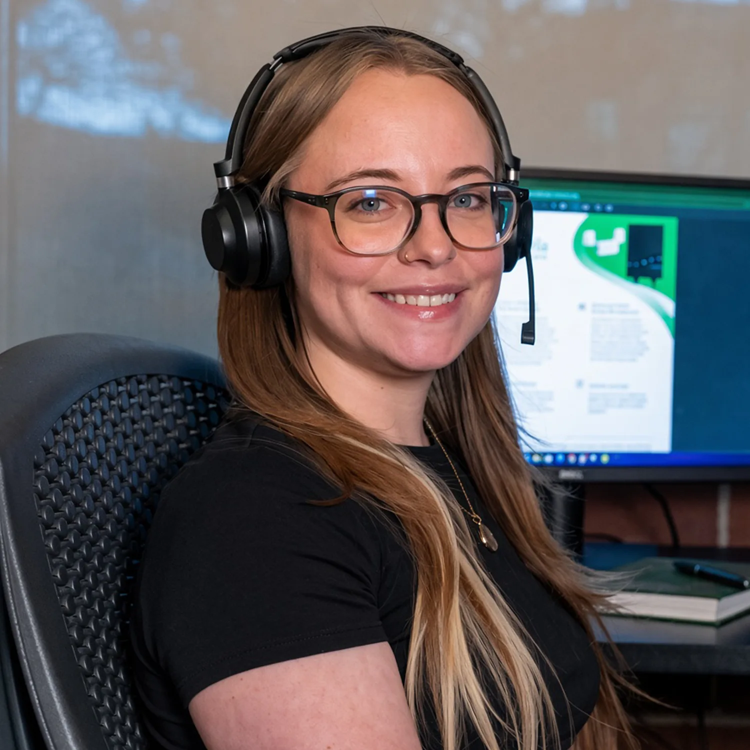 An Emporia customer service specialist at her desk in Colorado, wearing a headset